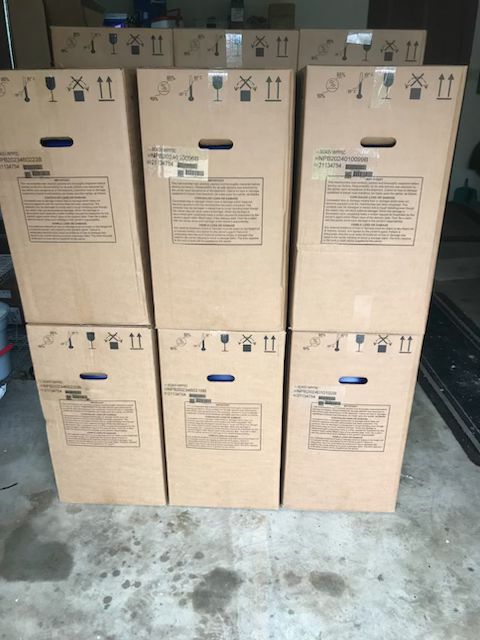 Six Chart/MVE MVE SC 4/2V or SC 4/3V vapor shippers (holds 280 or 120 straws; includes three-year vacuum warranty) are stacked on a concrete floor, perfect for organizing semen embryo shipping in your garage or storage area.