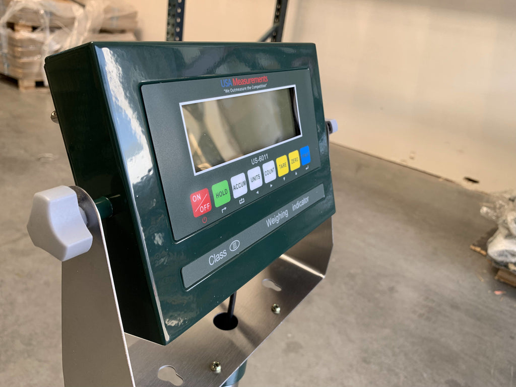 A Semen Tanks - Select Genetics Bench Cryo-Alert Scale 24"x24" with US-6011 Indicator and stacklight, mounted on a metal stand, is shown in an industrial warehouse as part of a tank scale system. Capacity: 90 lbs.