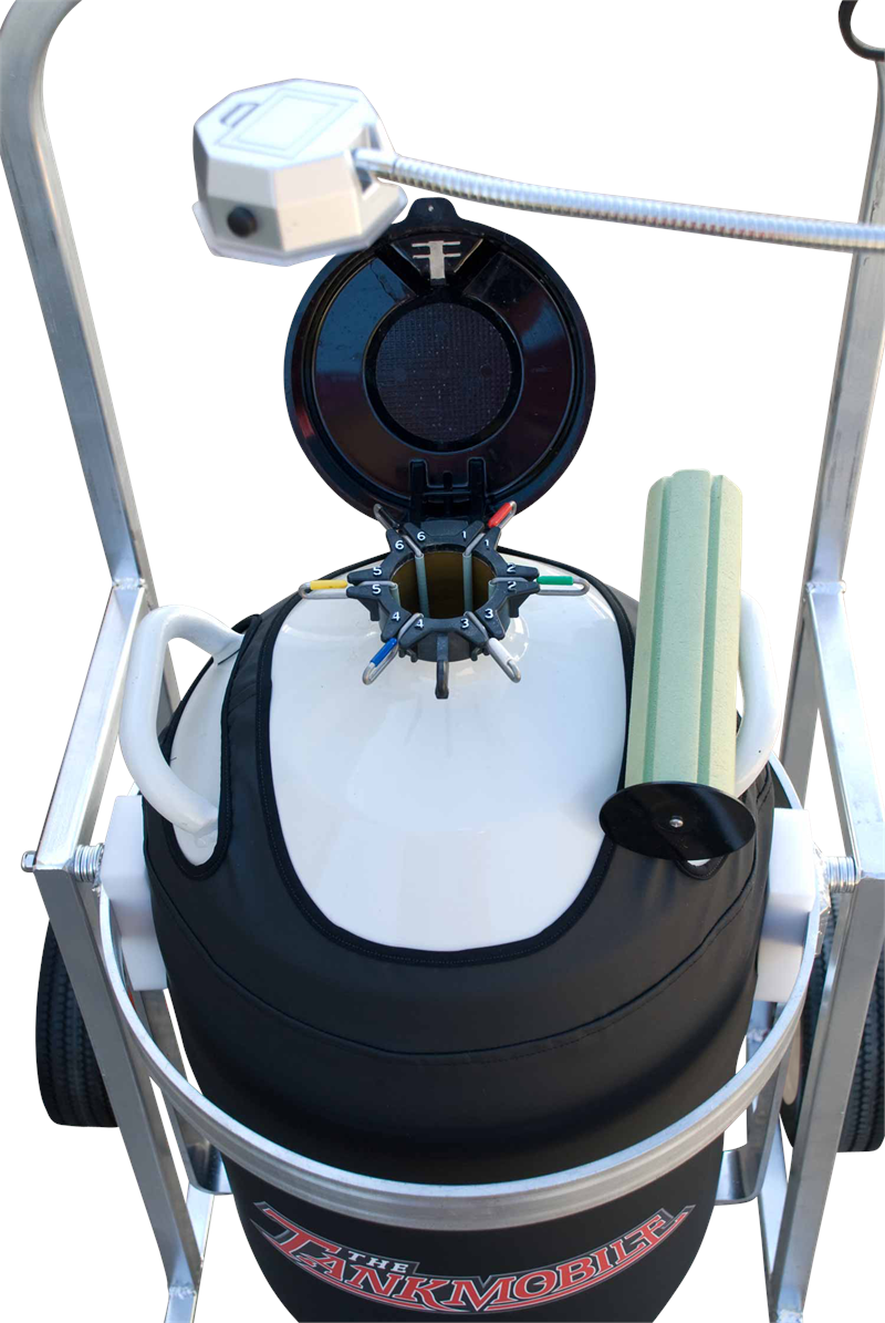 A close-up of the Chart/MVE CryoTipper, a white cylindrical aluminum cryogenic tank with padded black cover, open circular lid, LN2 hose, and foam tubes, all on a wheeled metal frame.