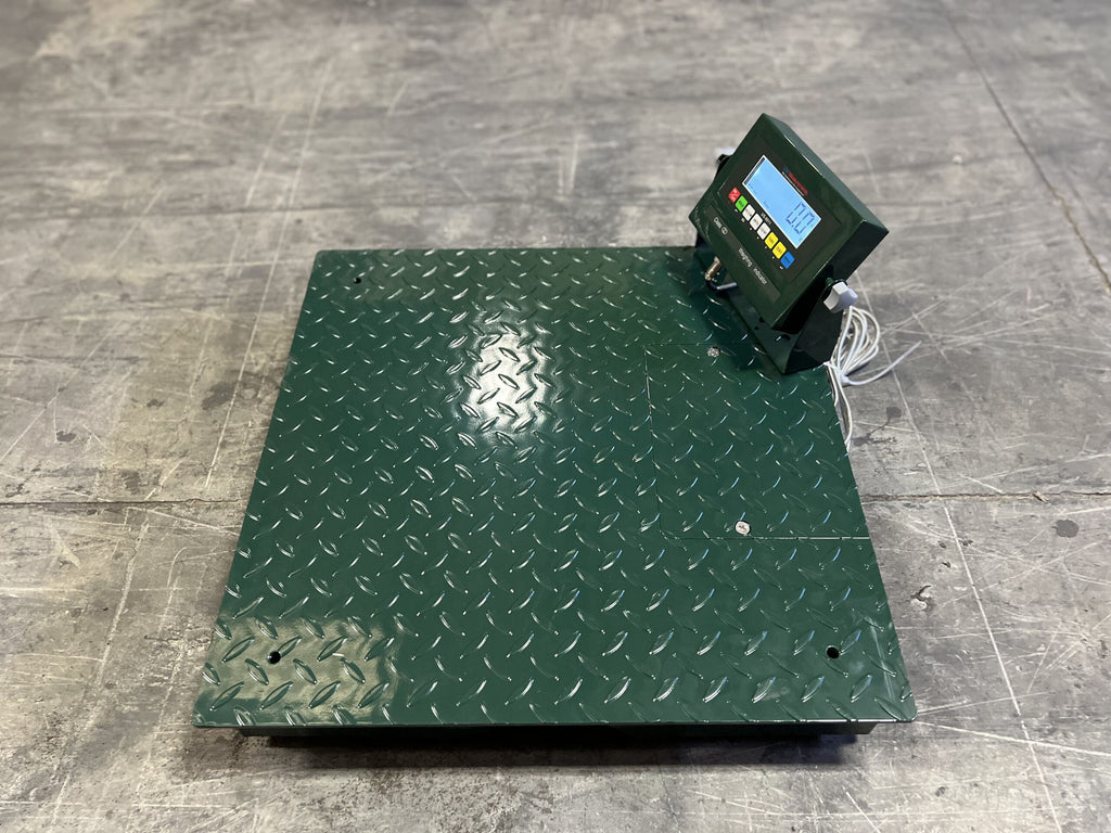 The CRYO-ALERT Floor Scale by Semen Tanks - Select Genetics, with a weight indicator and stack light, weighs up to 110 lbs and is ideal for semen or embryo tank monitoring. White cables connect its display as it sits on a gray concrete floor.