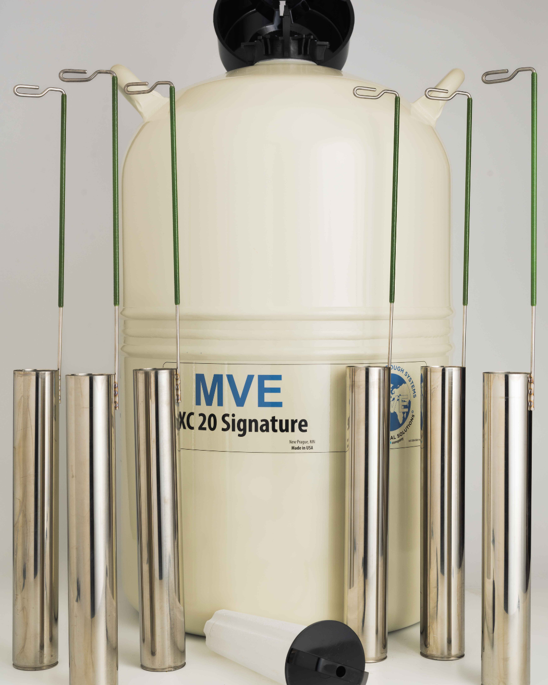 A Chart/MVE XC 20 Signature liquid nitrogen tank for semen storage (holds 660 straws, 20 weeks, five-year vacuum warranty) is shown with five metal canisters with green handles and a black-and-white lid on a light background.