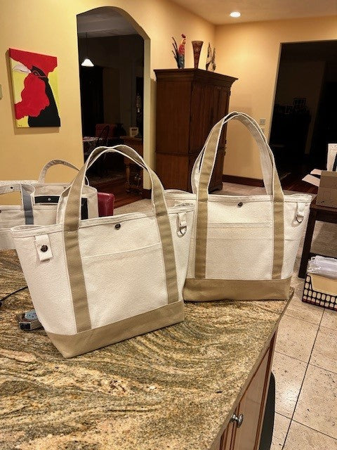 Two Semen Tanks - Select Genetics Totes for Everyday Use with beige accents and 18 or 24 inch straps sit on a granite kitchen counter, warmly lit to highlight these roomy, stylish bags perfect for daily use.