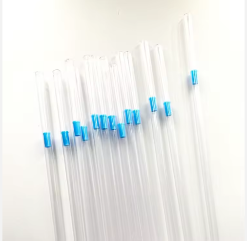 A set of clear plastic straws with blue bands from the RR AI Kit—With Electric Thaw Unit are arranged diagonally on a white surface, resembling kit components.