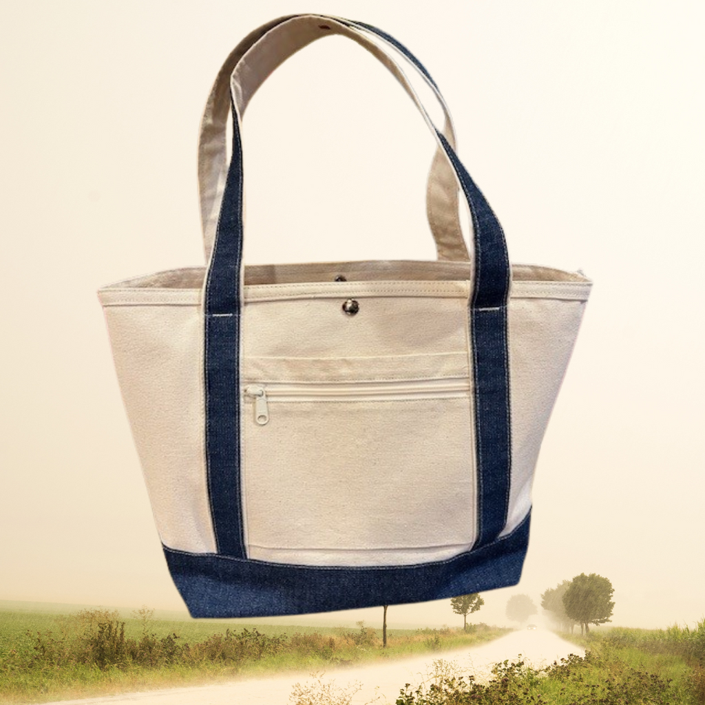 The Semen Tanks - Select Genetics Totes for Everyday Use bag, featuring denim accents and your choice of 18 or 24 inch straps, is shown in beige with dark blue straps against a scenic rural path backdrop.