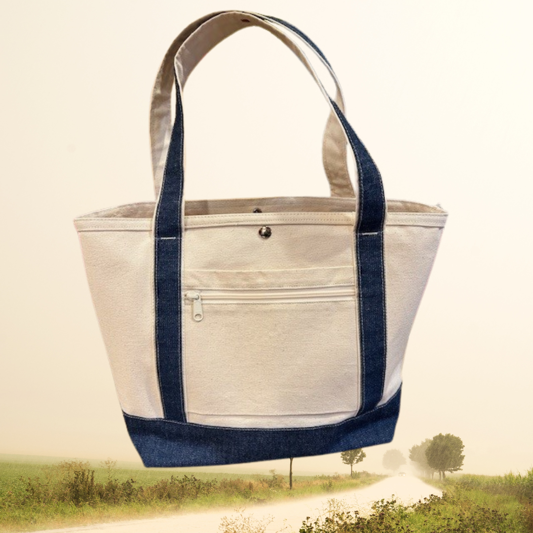 The Semen Tanks - Select Genetics Totes for Everyday Use bag, featuring denim accents and your choice of 18 or 24 inch straps, is shown in beige with dark blue straps against a scenic rural path backdrop.