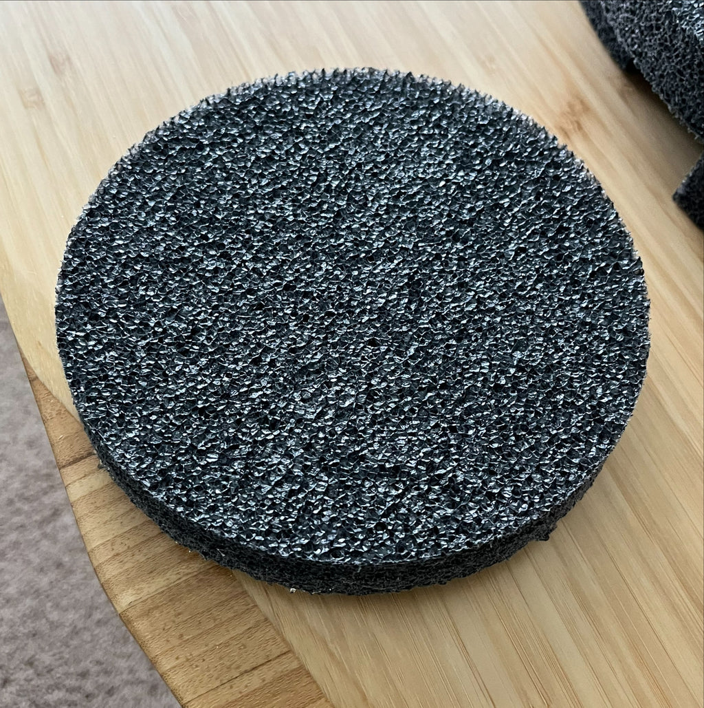 A round, black, porous foam pad from Chart/MVE sits on a light wooden surface—ideal as a TOTAL KIT Foam Replacement Piece (sides, top, bottom) for 4/2 & 4/3 V mushroom MVE Protective Shipping Containers.