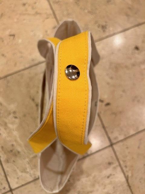 The Semen Tanks - Select Genetics Totes for Everyday Use, featuring yellow accents and 24-inch straps, is displayed on a beige tiled floor and viewed from above.